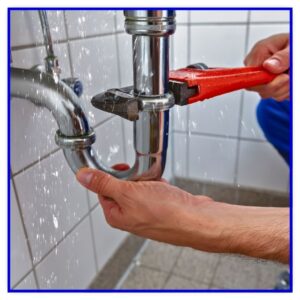 A plumber fixing a leaky pipe.