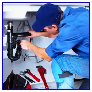 A plumber fixing pipes under bathroom sink.